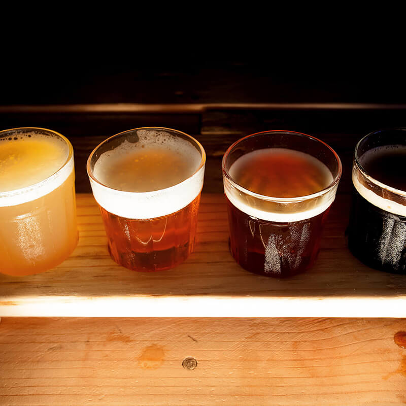 Four frothy beer glasses for tasting.