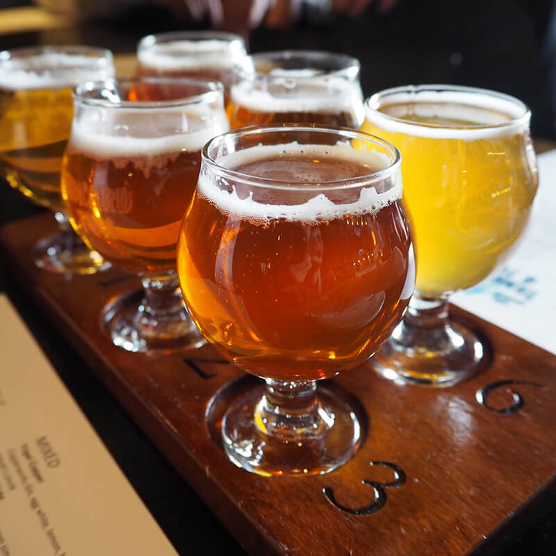 A flight of beer in large glasses.