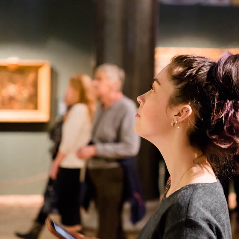 A woman gazing at an art piece in a museum.