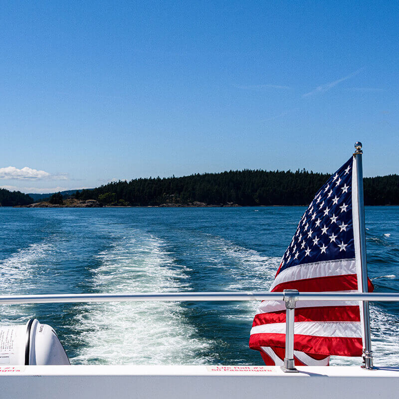 A boat flying the American flag on a bright summer day.