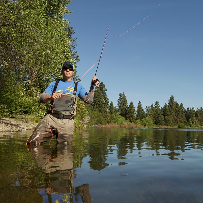 A man fly fishing on a warm summer day in Spokane Valley.