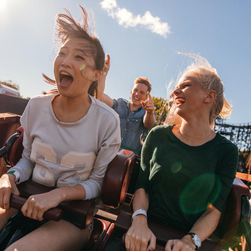 Smiling group of friends on a wooden roller coaster at a theme park near Spokane Valley.